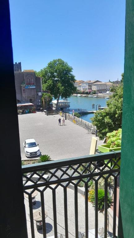 - un balcon avec vue sur un parking avec une voiture dans l'établissement Appartement ravissant au bord de l'Hérault, à Agde