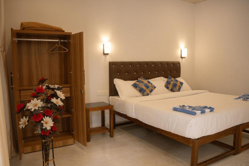 a bedroom with a bed and flowers in a room at Anna Cottages Agonda in Agonda