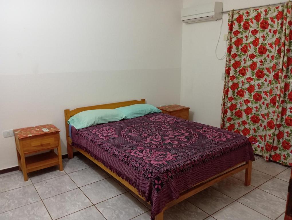 een slaapkamer met een bed met een paars dekbed bij Departamentos céntrico Las Guayabas in Puerto Iguazú