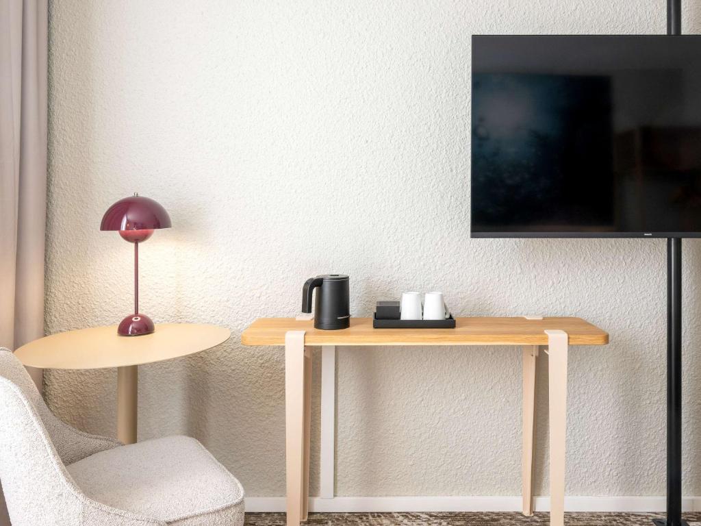 TV a/nebo společenská místnost v ubytování Novotel Grenoble Nord Voreppe