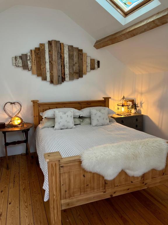 a bedroom with a wooden bed with white sheets and pillows at The Hayloft in Hereford