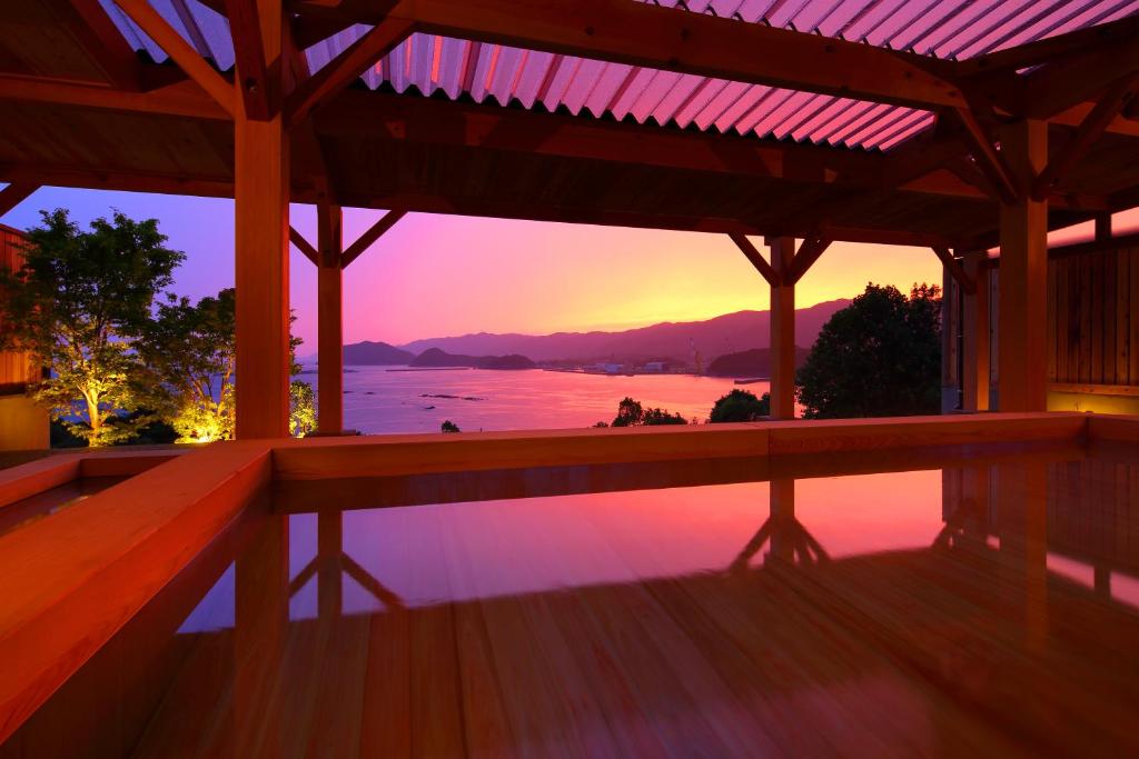 desde la terraza de una casa con puesta de sol en 宿毛リゾート椰子の湯, en Sukumo