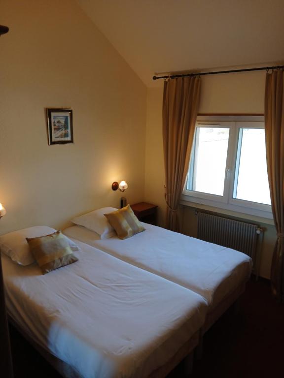 Postel nebo postele na pokoji v ubytování Hôtel l'Orée des Roches