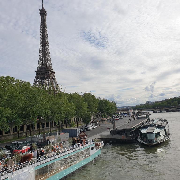 un bateau dans la rivière près de la tour eiffel dans l'établissement Studio Eiffel Tower Trocadero, à Paris