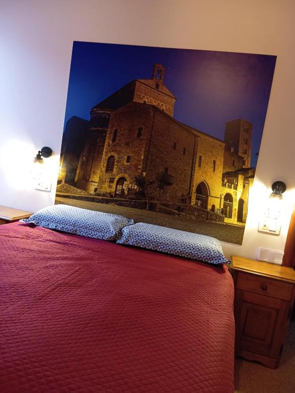 a bedroom with a bed with a picture of a building at Vicolo della Quiete Anagni in Anagni