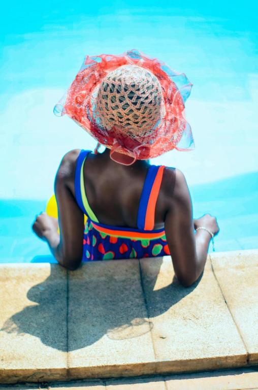 a child in a swimsuit sitting on the edge of a pool at Antalya Apart in Antalya