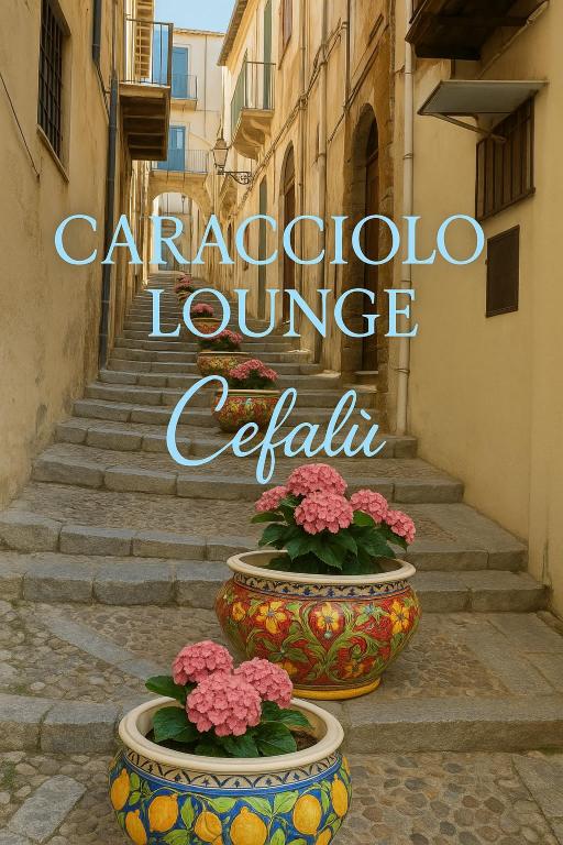 two large vases with flowers in them on a street at Caracciolo Lounge in Cefalù
