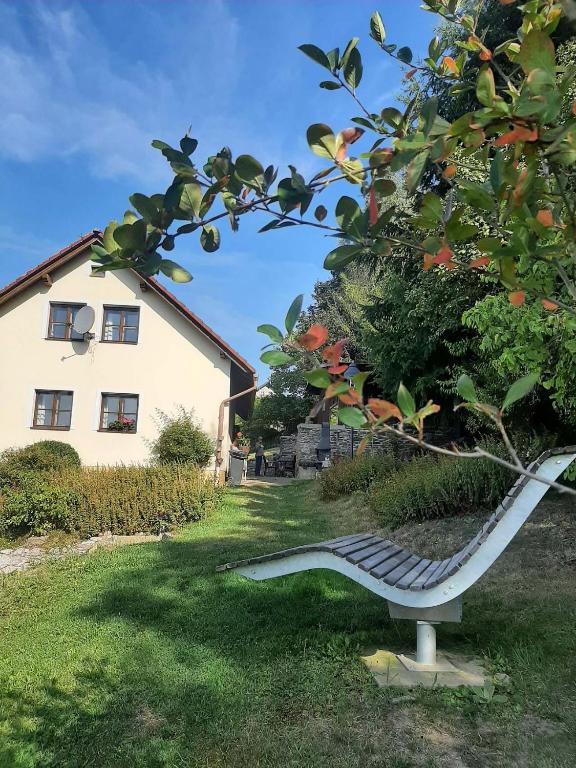 a bench sitting in the grass next to a house at Chata Salicka Bozkov in Bozkov