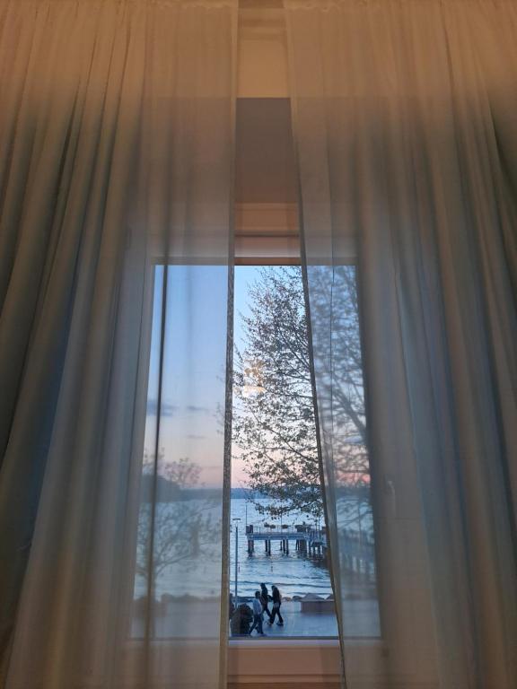 a window with a view of the water and a pier at Light Blue in Anguillara Sabazia