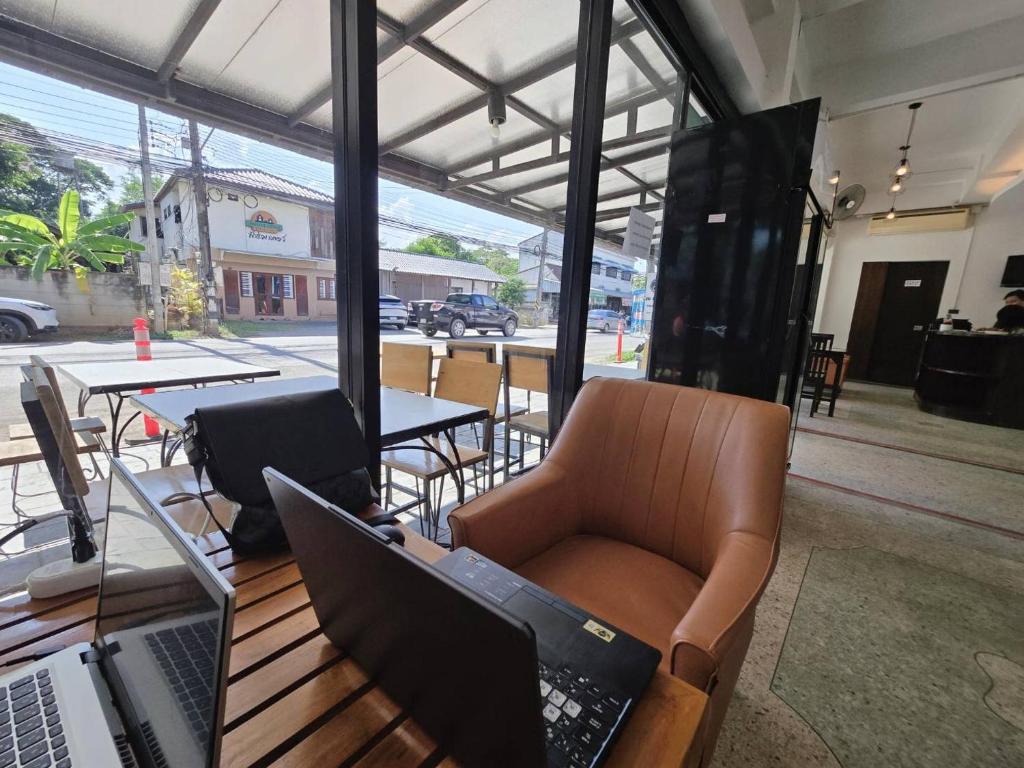 A laptop workspace in a lounge chair beside the hotel’s street-facing windows.