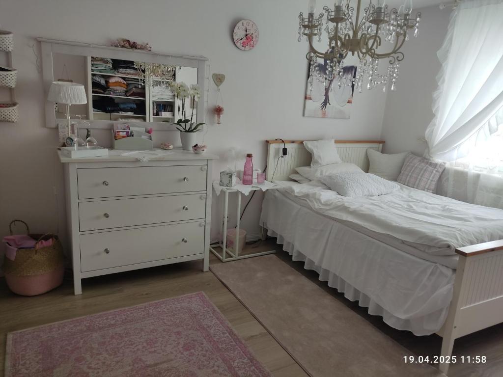 a bedroom with a white bed and a dresser at Romantischer Traum, nur 1 Tag im voraus zu buchen, mit TV inkl Netflix in Bielefeld