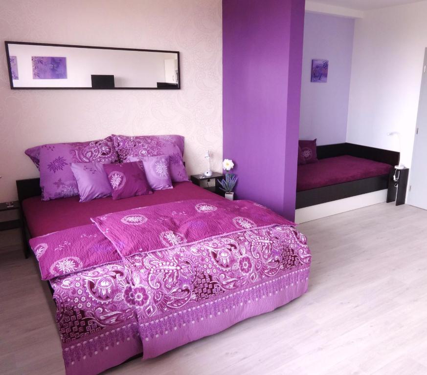 una camera da letto viola con letto viola e specchio di Apartments 4U center + free parking a Olomouc