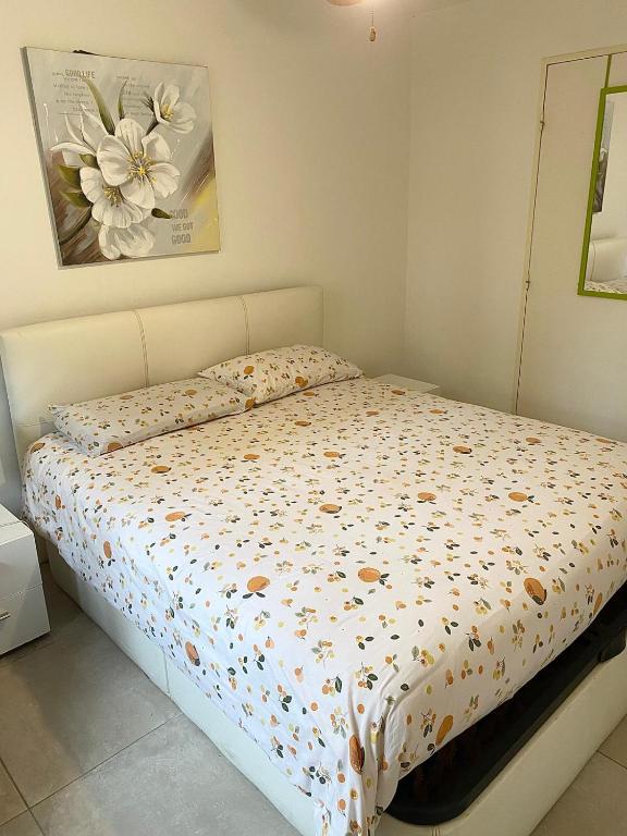 - un lit avec une couette à fleurs dans une chambre dans l'établissement bellissimo appartamento, à Nice
