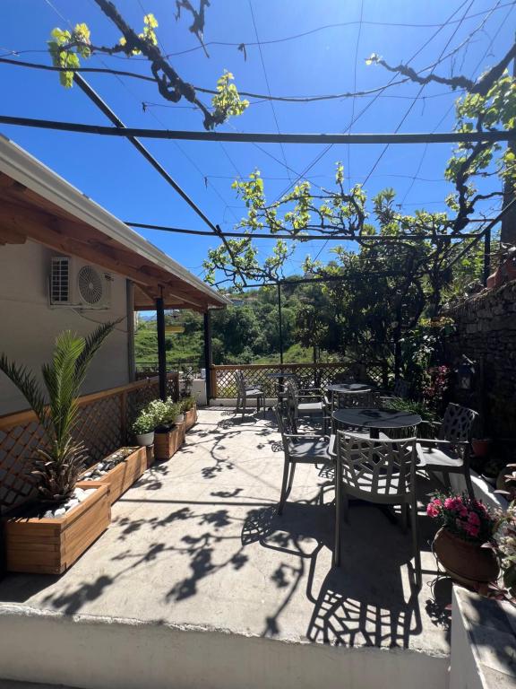 a patio with some tables and chairs and trees at Dalipi's Guest House in Gjirokastër