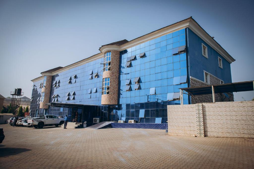 a blue building with birds on the side of it at World Class Hotel & Apartments in Abuja