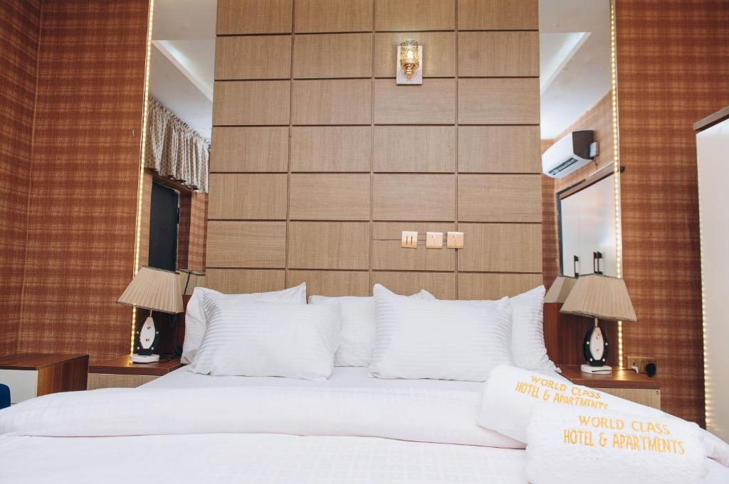 a bedroom with a large bed with white pillows at World Class Hotel & Apartments in Abuja