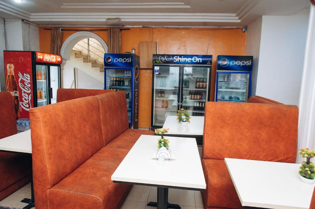 a restaurant with two tables and two soda machines at World Class Hotel & Apartments in Abuja
