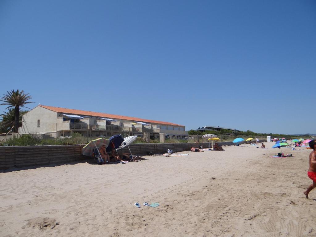 un groupe de personnes sur une plage de sable dans l'établissement Magnifique appartement les pieds dans l'eau Presqu'île de Giens, à Hyères