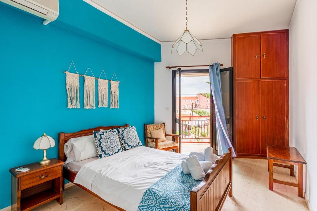 1 dormitorio con paredes azules y 1 cama con escritorio en Central Apartment for 4 by Alecos Studios, en Póros