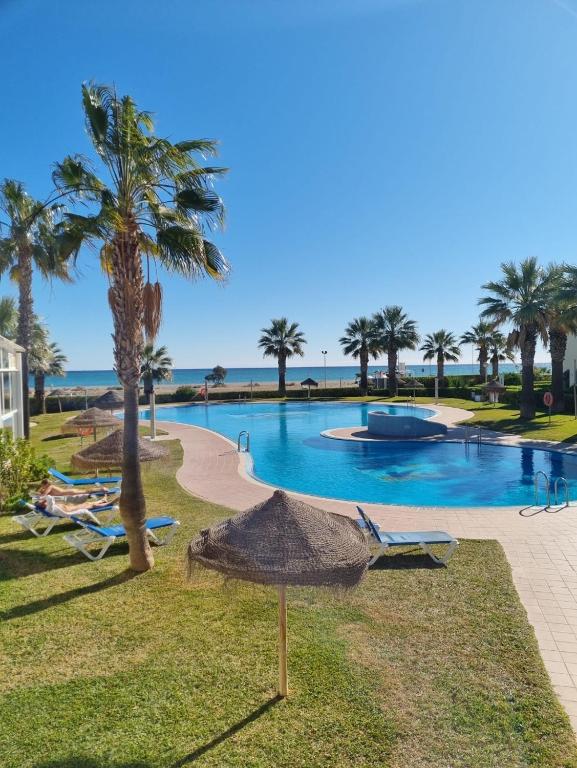 einen Pool mit Palmen und Liegestühlen in der Unterkunft Vera Natura isleta nudista in Vera