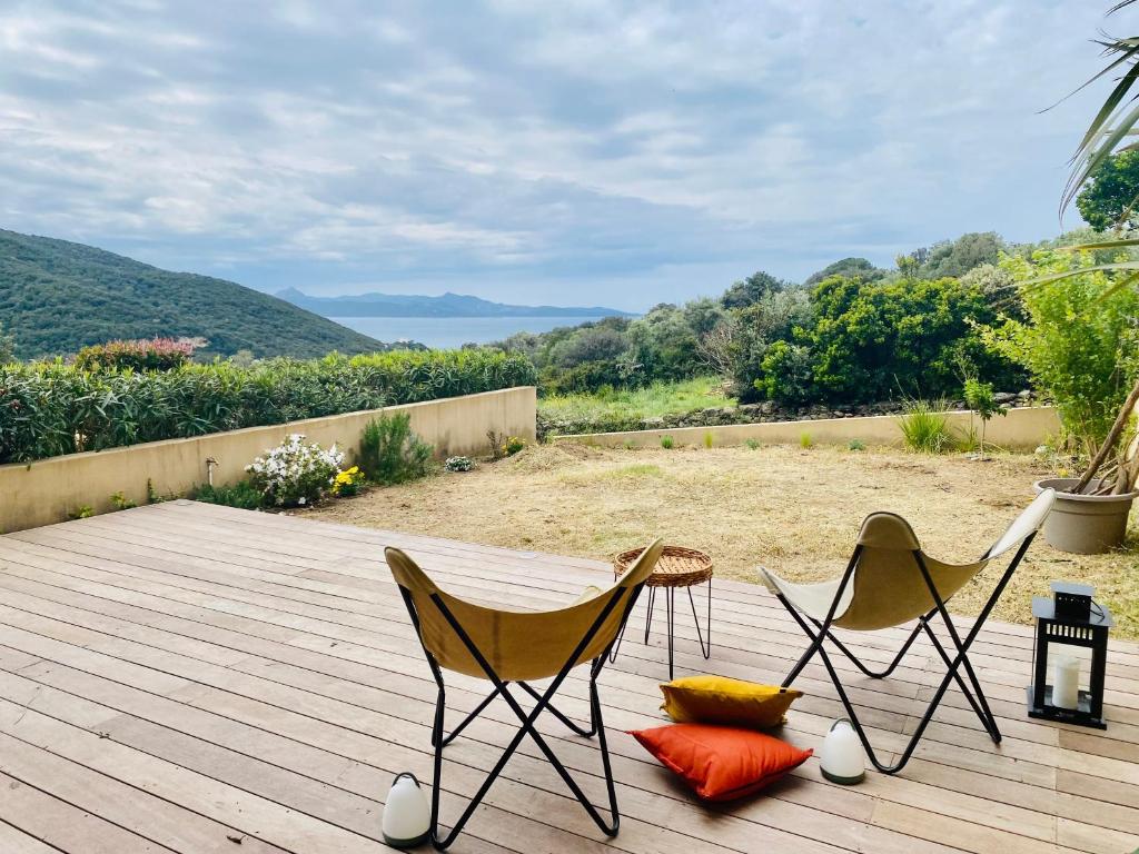 deux chaises et une table sur une terrasse en bois dans l'établissement T2 Farinole, vue mer sur le golfe de St Florent, plage a pied, à Farinole