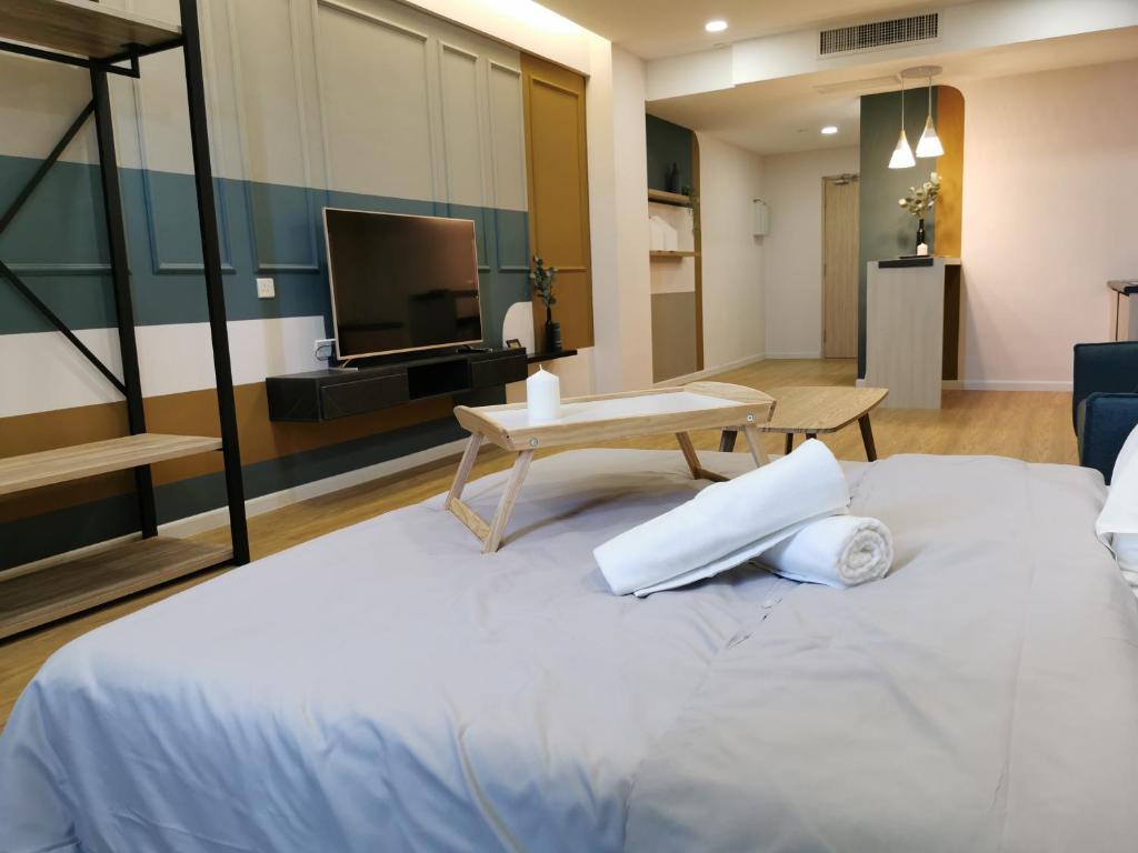 a hotel room with a bed and a tv at AGROWTH at Aru Suites in Kota Kinabalu