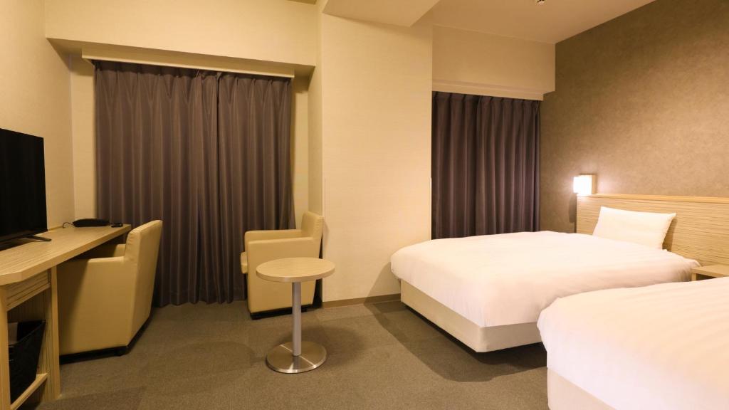 Postel nebo postele na pokoji v ubytování Dormy Inn Mishima