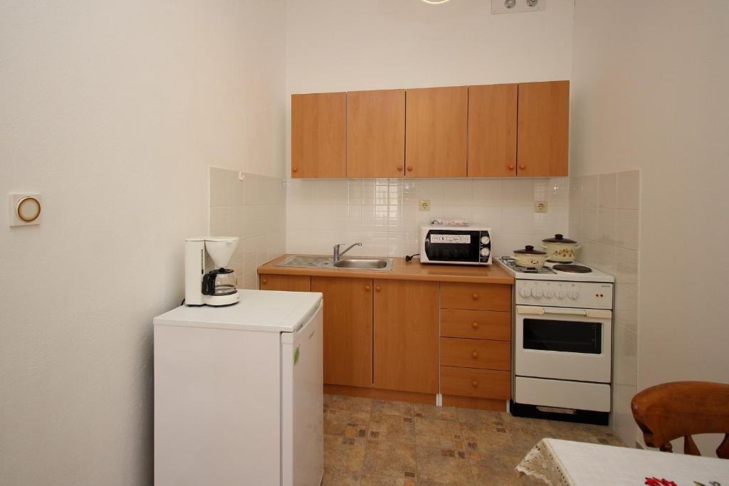 a kitchen with a white refrigerator and a stove at Apartmani Štefica in Razvala