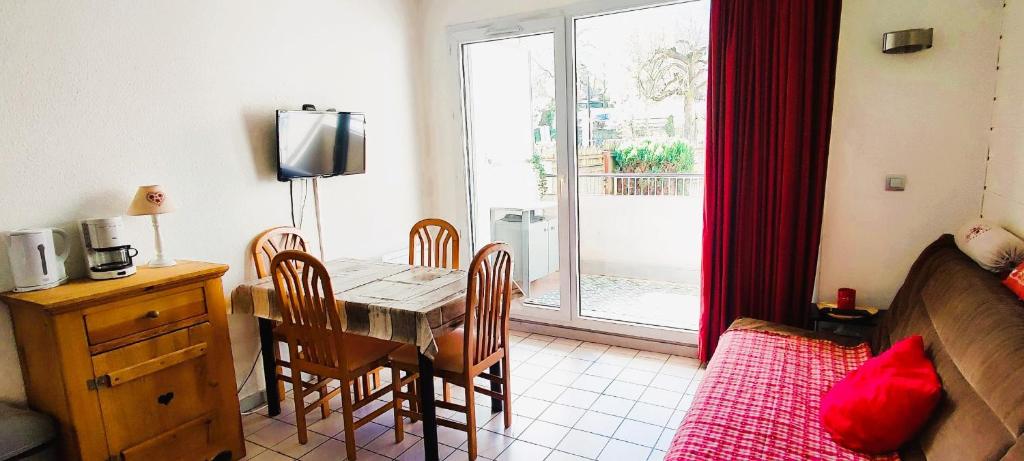 un salon avec une table et des chaises et un lit dans l'établissement L'Ame du chalet, à Allevard
