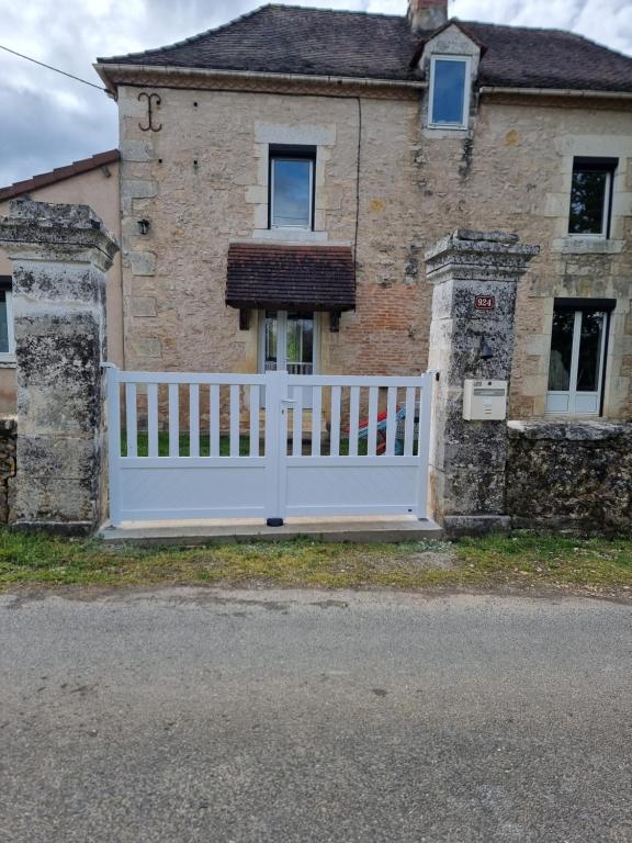 une clôture blanche devant une maison dans l'établissement Gîte Sarazac, à Mayac