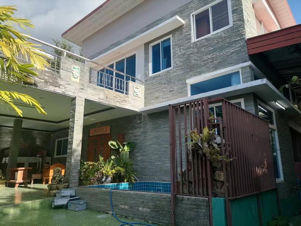 a house with a swimming pool in front of it at Spacious and cozy Thai House in Ban Bang Khu