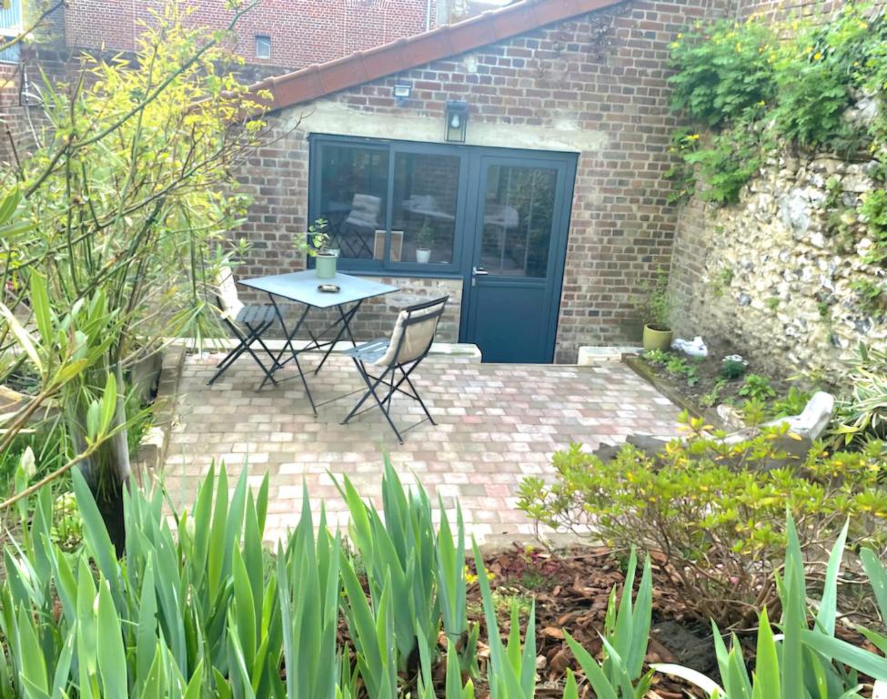 un patio avec une table et des chaises devant un bâtiment dans l'établissement Le Clos De Marissel - Terrasse et Jardin, à Beauvais