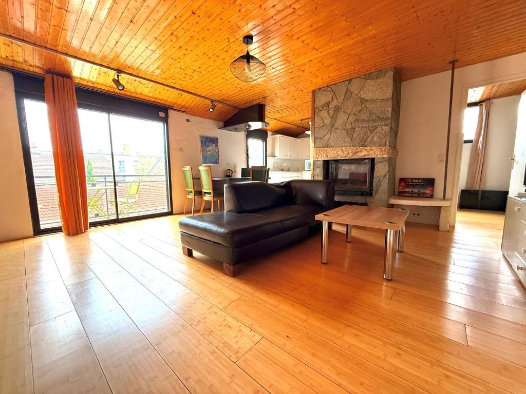 un salon avec un canapé en cuir et une table dans l'établissement Chaleureux appartement centre ville proche gare., à Besançon