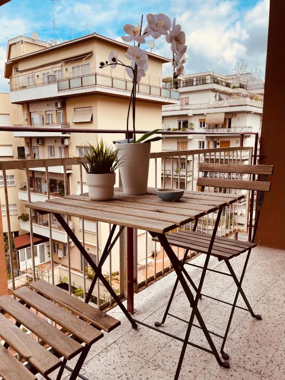 un tavolo e delle sedie su un balcone con un edificio di Lazy Time Apartment a Roma