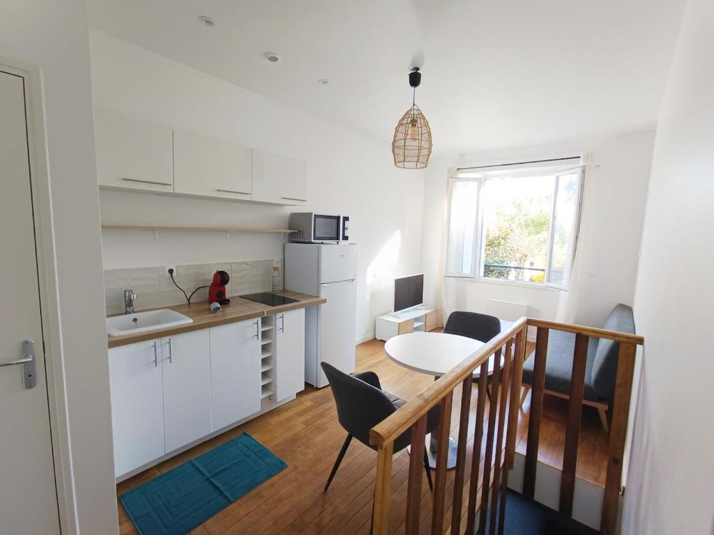 une cuisine avec une table et une salle à manger dans l'établissement Charming duplex, à Vitry-sur-Seine