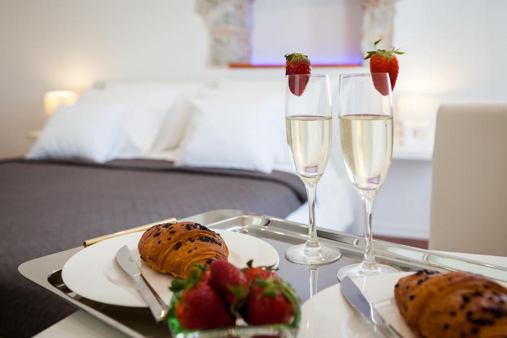 a tray with two glasses of champagne and strawberries on a table at Rooms Supreme Spalato in Split