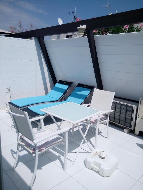 deux chaises et une table sur un balcon dans l'établissement Villa 3, Port Nature au village naturiste, au Cap d'Agde