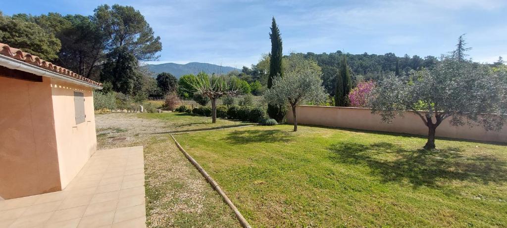 un jardin avec des arbres et un mur avec une cour dans l'établissement La Ventourette, à Le Barroux