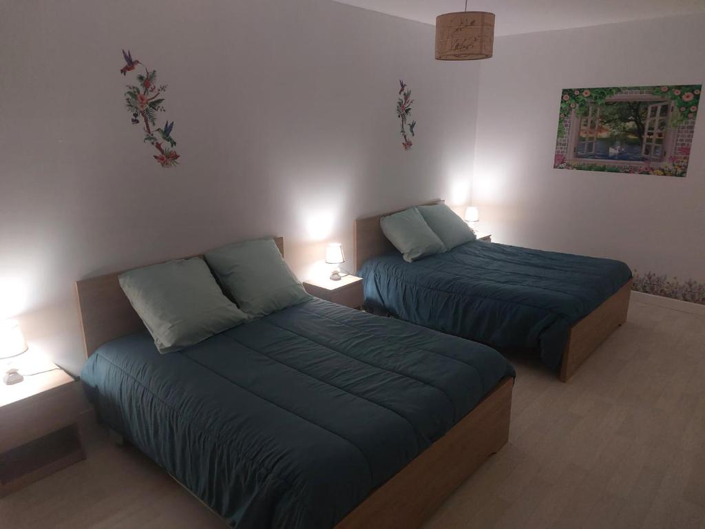 La Celle-sous-GouzonにあるGîte de la tuilerieのランプ2つが付いた部屋のベッド2台