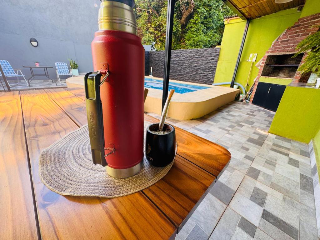 un cilindro de queroseno rojo sentado en un suelo de madera en El descanso acá, en Posadas