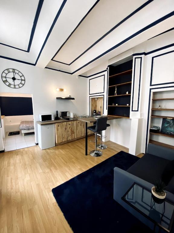 - un salon avec une table et une horloge murale dans l'établissement Loft au coeur du centre historique, à Narbonne