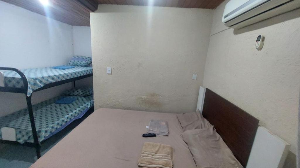 リオデジャネイロにあるHostel Bom e Familiarの小さな客室で、ベッド1台、二段ベッド2組が備わります。
