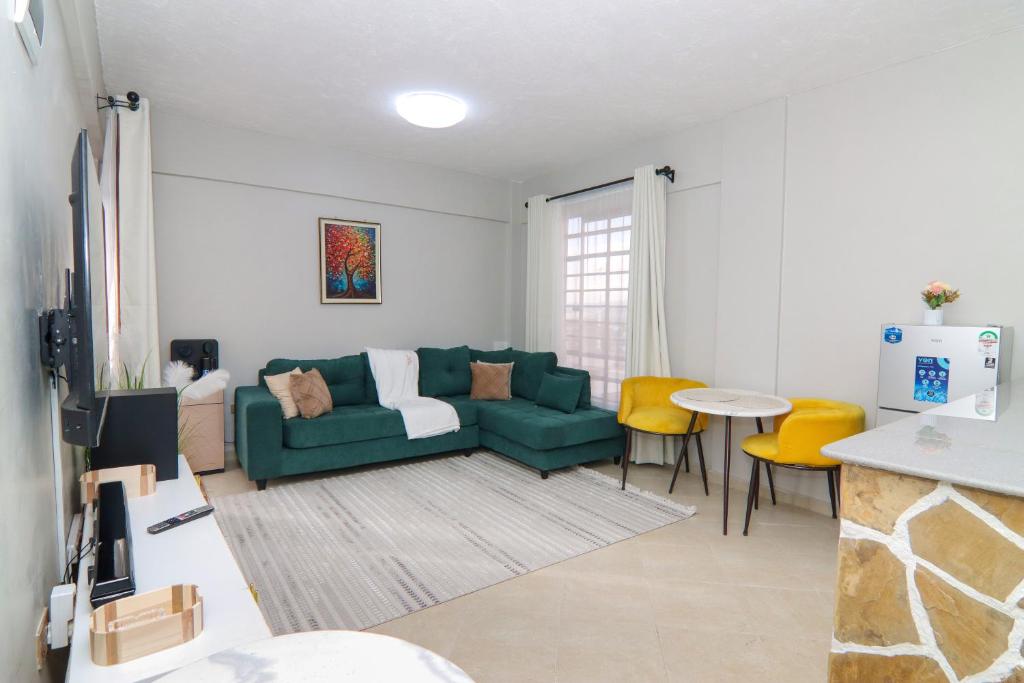 - un salon avec un canapé vert et des fauteuils jaunes dans l'établissement Jay Homes - Rehema Apartments, à Naivasha