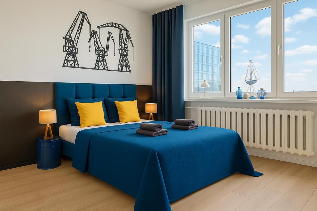 a bedroom with a blue bed with two towels on it at Good Night in Szczecin in Szczecin