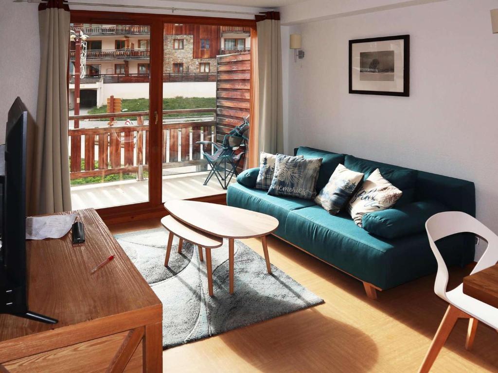 un salon avec un canapé et une table dans l'établissement Appartement skis aux pieds avec piscine (6 pers) - Les Orres 1800 - FR-1-322-480, aux Orres