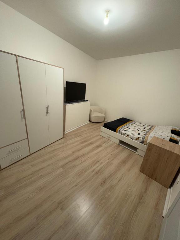 Cette petite chambre comprend un lit et une télévision. dans l'établissement Studio cosy, à Le Teil