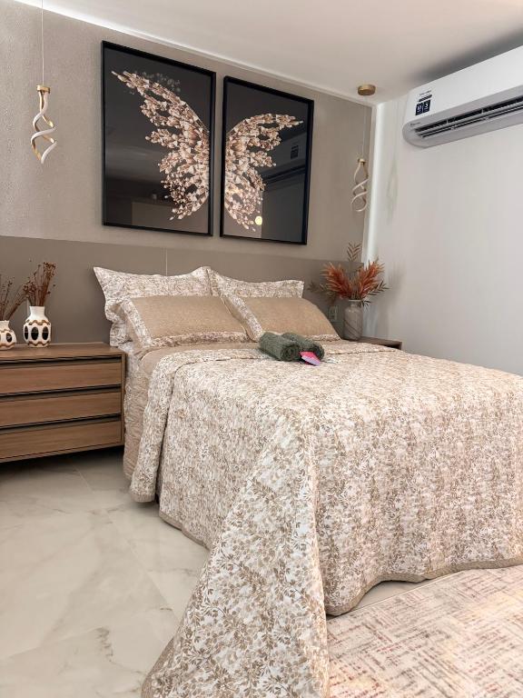 a bedroom with a bed with a comforter at Flat luxury hotel cove in Maceió