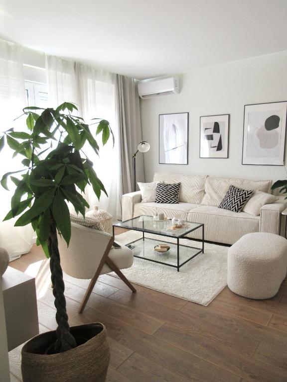 a living room with a couch and a potted plant at Japandi Home in Niš