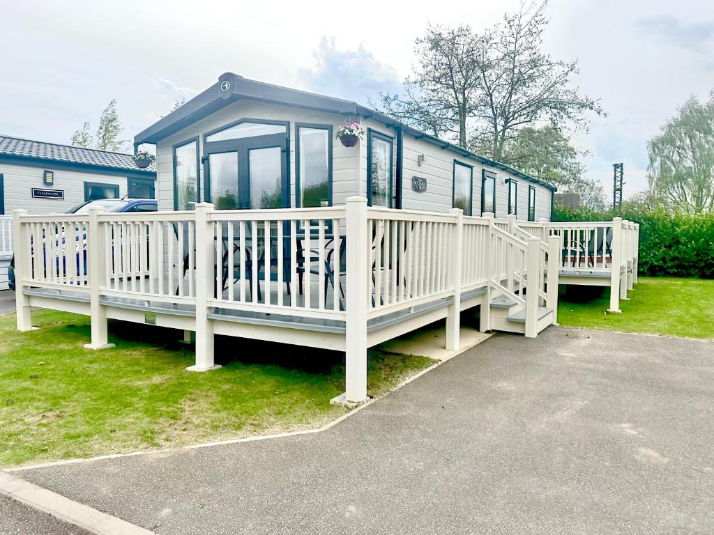 ein weißes Wohnmobil mit Veranda und Haus in der Unterkunft Burano Nook - Tattershall Lakes in Tattershall