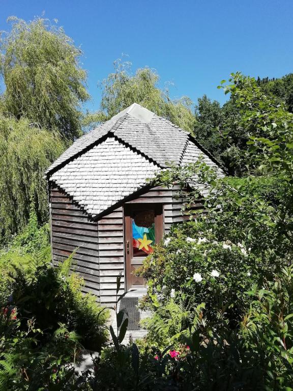 une petite maison avec une fenêtre dans un jardin dans l'établissement Havre de paix entre mer et forêt, à Ploumilliau